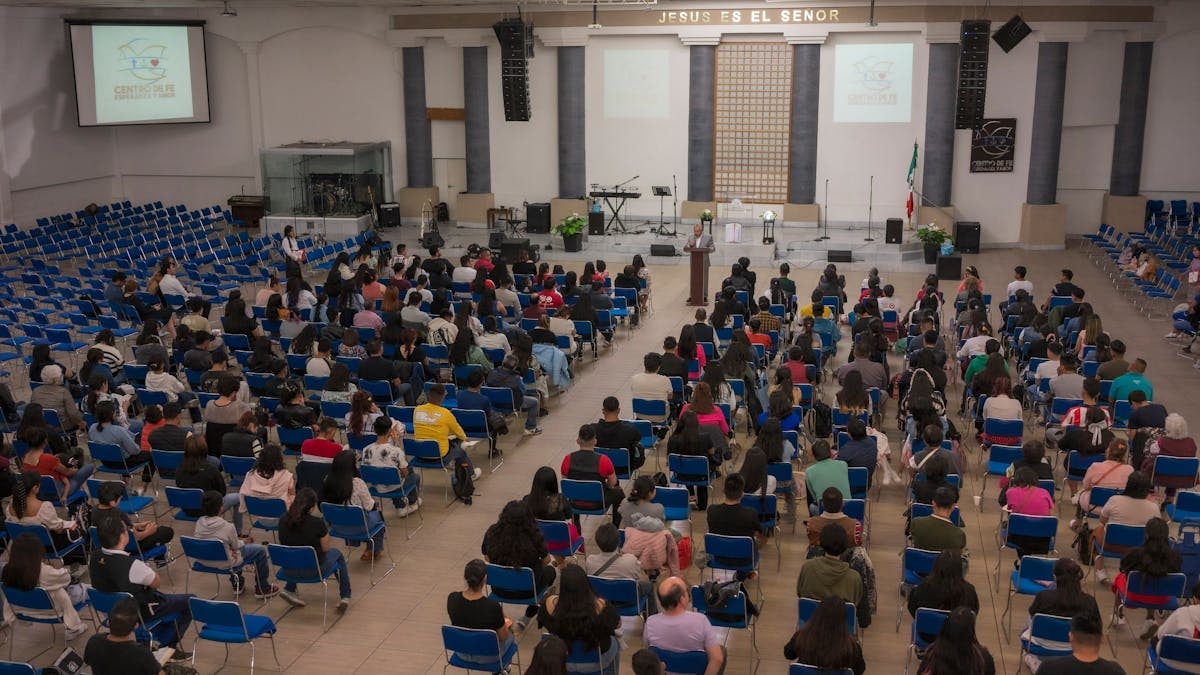 A large audience seated in a church auditorium attending a seminar.